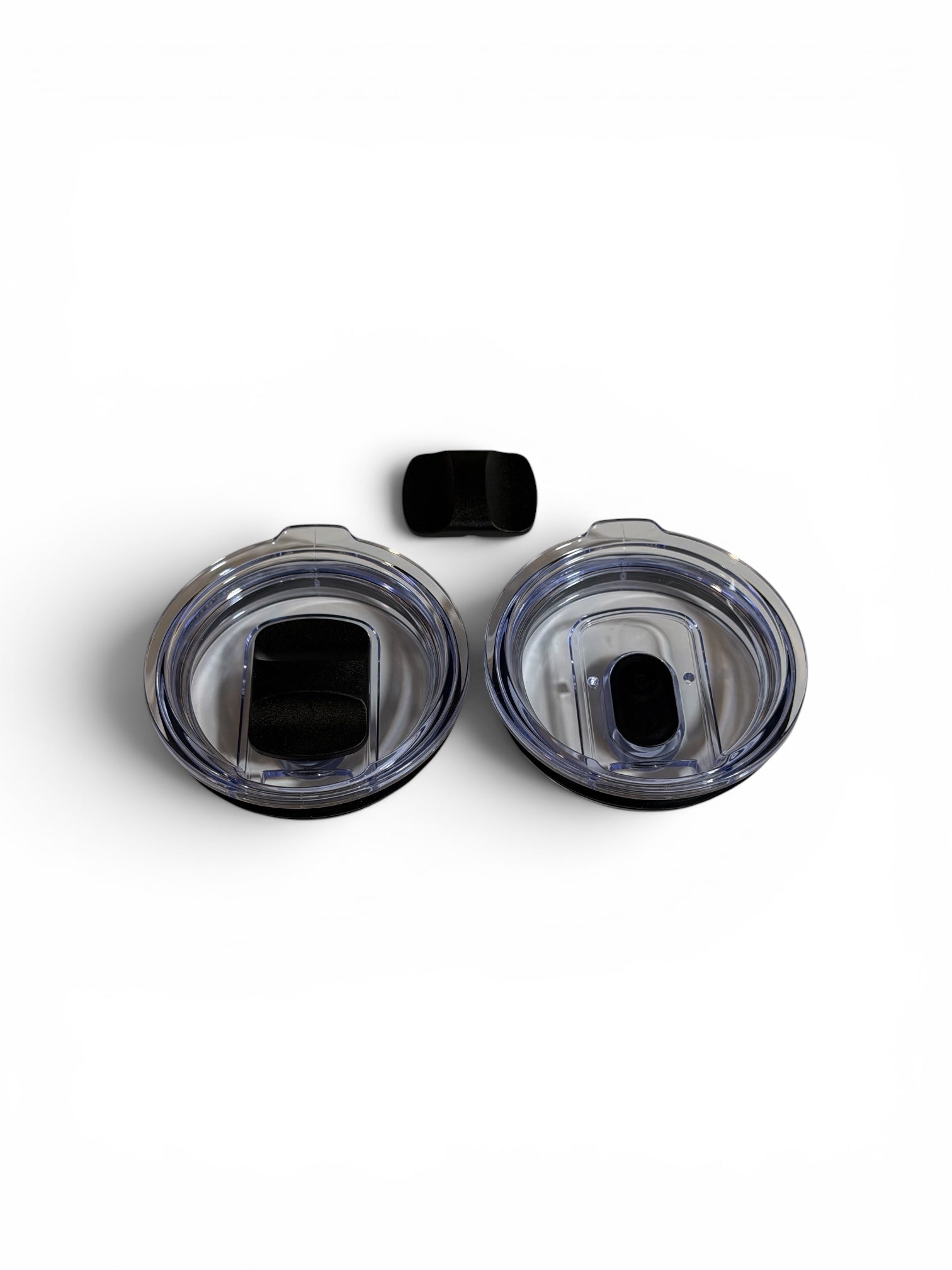 Two clear plastic covers with black centers on a white background