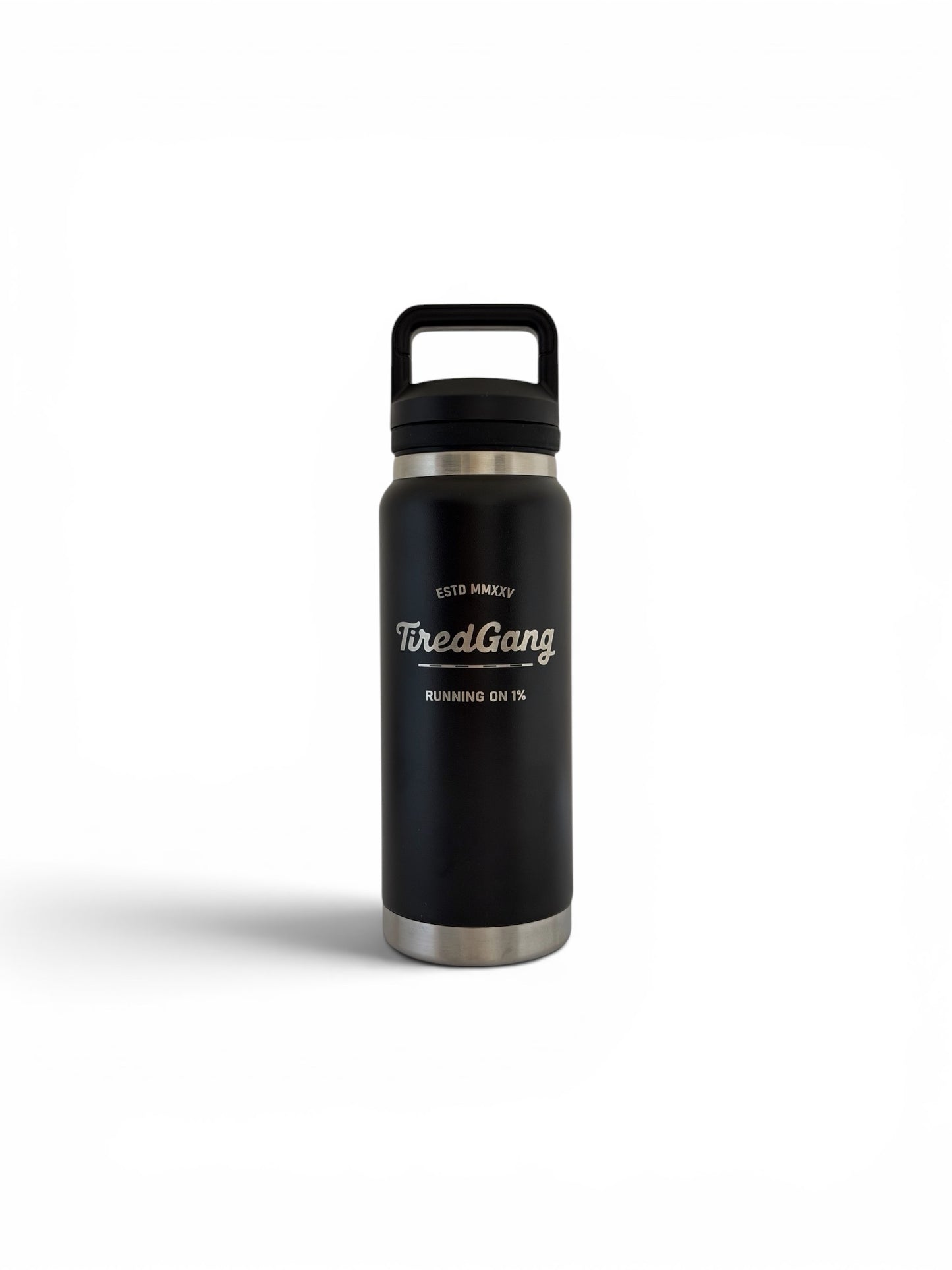 Black stainless steel insulated water bottle with a black screw-on lid and built-in carry handle. The front features a laser engraved TiredGang logo with the phrases “ESTD MMXXV” and “RUNNING ON 1%.” Black finish with stainless steel accents at the top and bottom. Product shown centered on a white background.